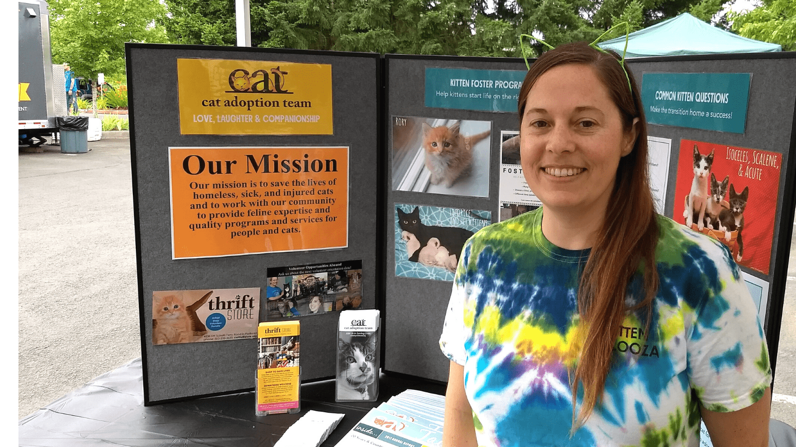 Mary Chambers wears a tie-dye T-shirt while staffing a CAT booth at an event.