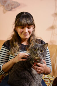 Dania sits with Ernie on her lap. Ernie looks at the camera. Dania looks at Ernie.