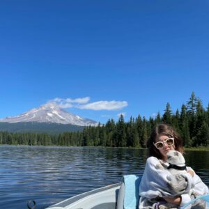 Mount Hood on a sunny summer day. Mara and Sticky snuggle in a canoe on a lake.