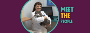 Eggplant background with blue and yellow text that reads, "Meet the People." Photo in center of Dr. Smith behind a counter holding a fuzzy cat named Huggie.