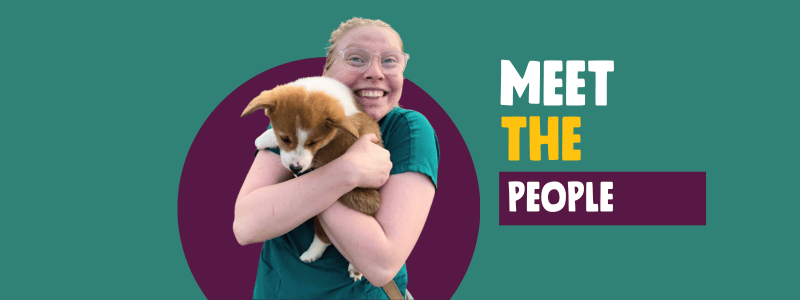 Teal background with yellow and white text, "Meet the People." Photo in center with purple circle behind it is of Meg holding a small corgi puppy. Meg is smiling.