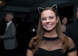 Wesleigh Ogle wears a black cocktail dress and rhinestone cat ears.