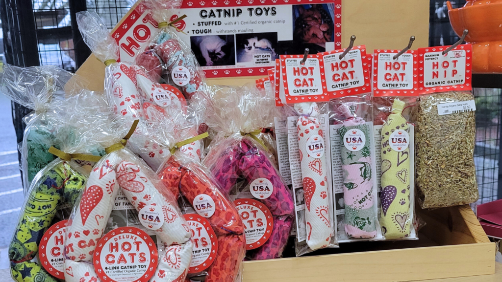 Display of HOT CAT catnip products in plastic bags with branded red and white labels.